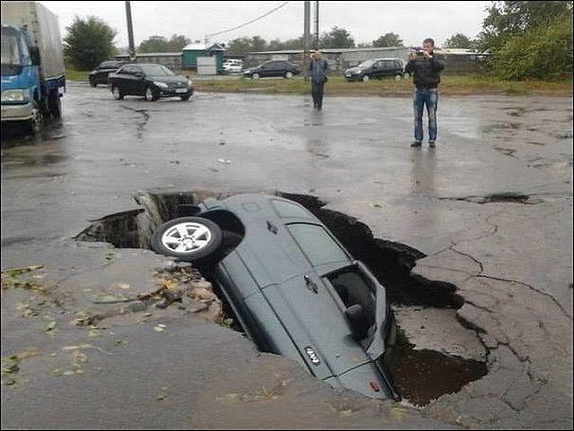 Auto dentro buca sulla strada