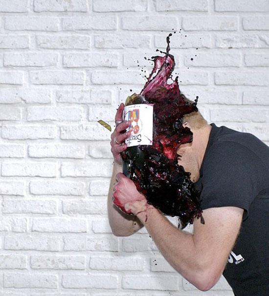Uomo che si spacca una bottiglia di vino in faccia