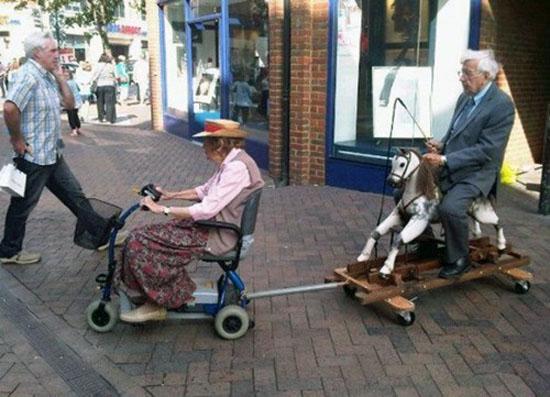 Nonna su carrozzina elettrica traina nonno su cavallo a dondolo