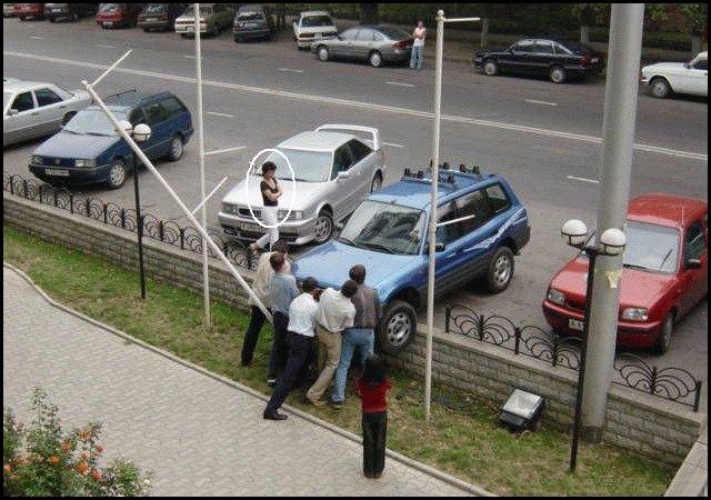 Foto Divertente: Donna che parcheggia auto sopra una recinzione
