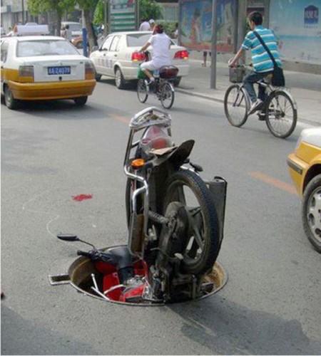 Motorino finito dentro un tombino