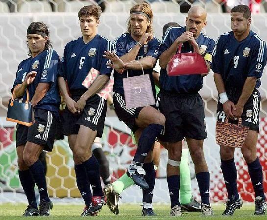 Foto Divertente: Calciatori in barriera con borse