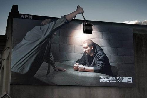 Foto Divertente: Cartellone pubblicitario con uomo con lampada per interrogatorio