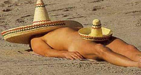 Uomo con sombrero sdraiato sulla sabbia