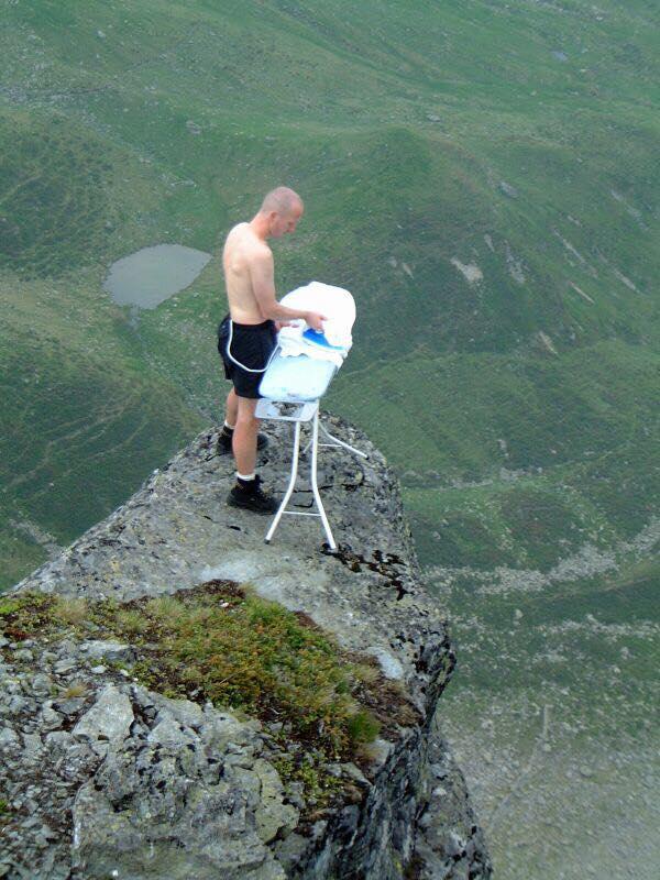 Uomo che stira sulla cima della montagna
