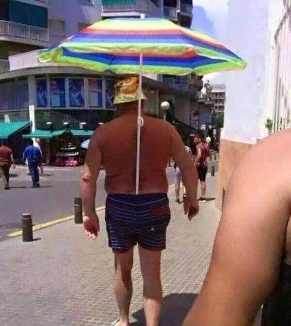 Foto Divertente: Uomo con ombrellone nei pantaloncini
