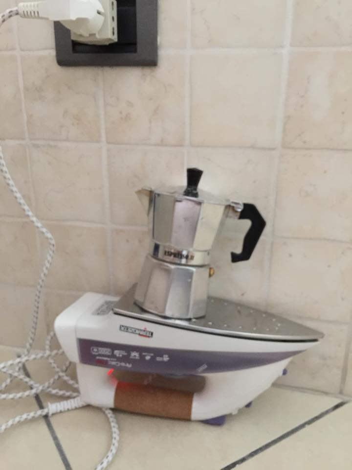 Macchinetta del caffè che si scalda sul ferro da stiro