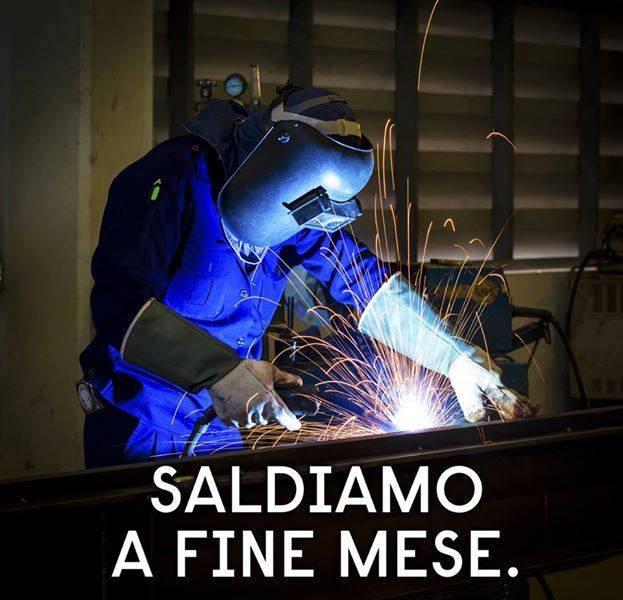 Uomo con mascherina che salda il ferro