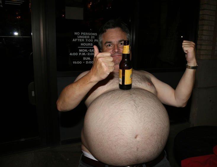Uomo con pancione enorme sul quale appoggia la birra
