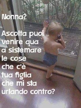 Bambino che telefona alla nonna mentre è alla finestra