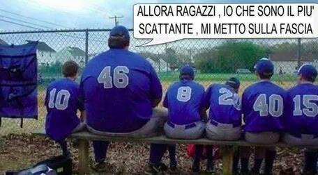 Uomo enorme seduto in panchina insieme ad altri giocatori