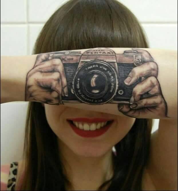 Braccio con tatuato una macchina fotografica