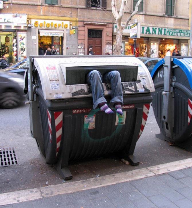 Uomo dentro cassonetto della spazzatura