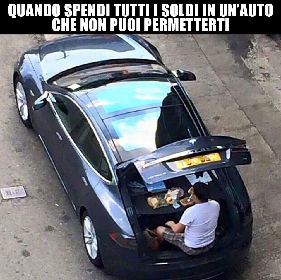 Uomo che pranza nel cofano dell'auto di lusso