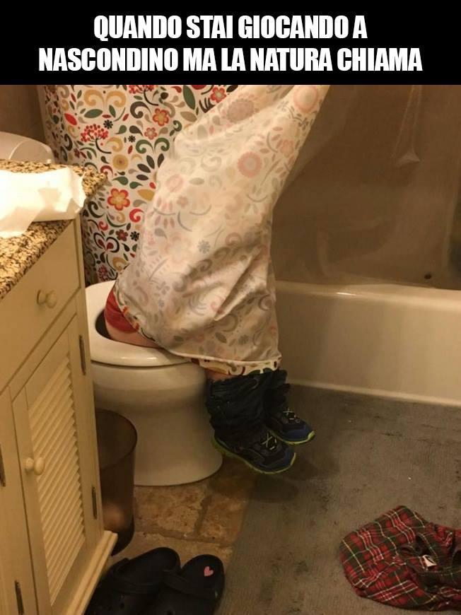 Foto Divertente: Bambino nascosto dietro alla tenda mentre è seduto sul wc