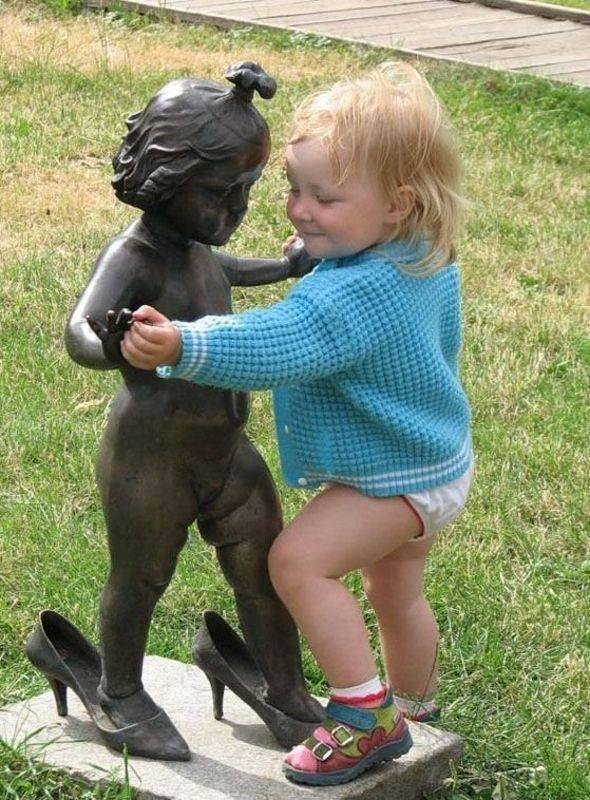 Foto Divertente: Bambina che fa il girotondo con una statua