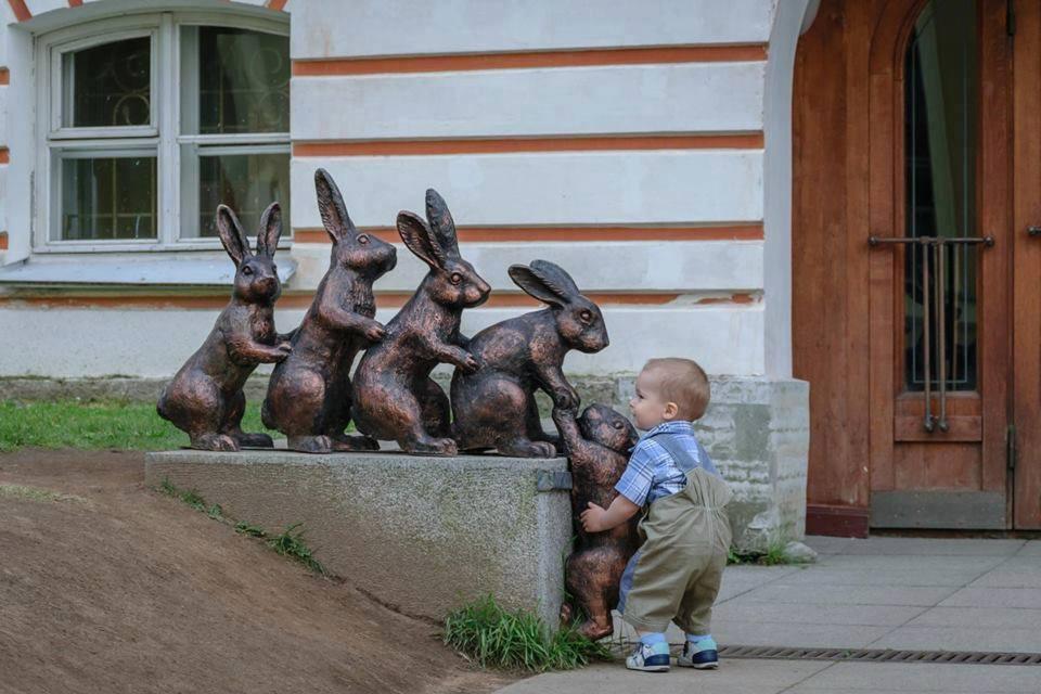 Foto Divertente: Bambino che tira su una statua a forma di coniglio 