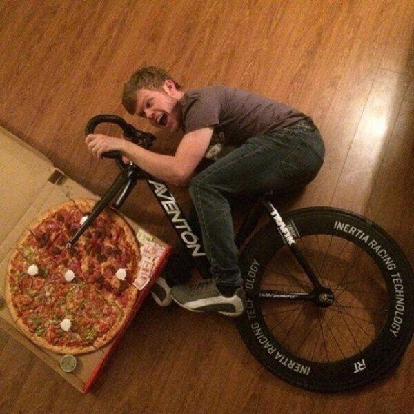 Uomo in bici con una ruota di pizza