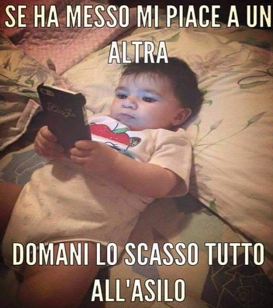Foto Divertente: Bambino sdraiato sul letto con cellulare in mano