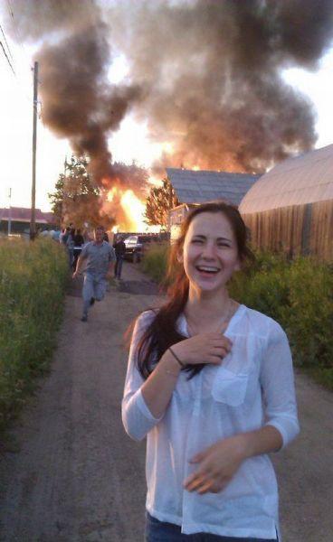 Ragazza che ride mentre dietro scoppia un incendio