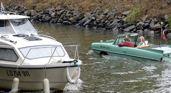 Barca a forma di macchina che viaggia nel fiume