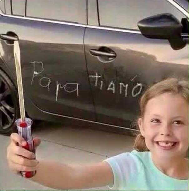 Foto Divertente: Bambina che riga la macchina del padre con cacciavite