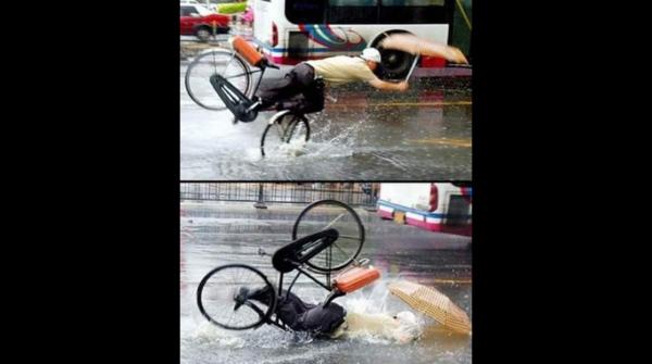 Uomo che cade dalla bici in una pozzanghera mentre piove