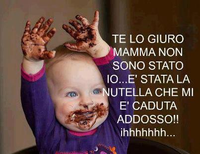 Foto Divertente: Bambino con mani in alto e tutto sporco di cioccolato
