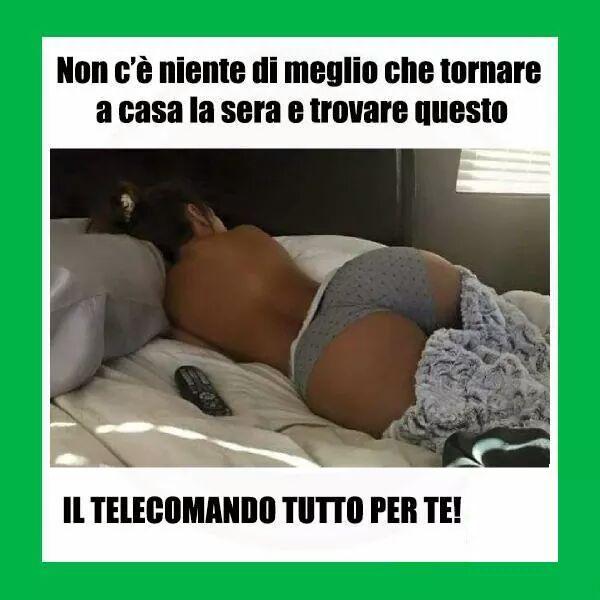 Donna in mutande sdraiata sul letto con telecomando vicino