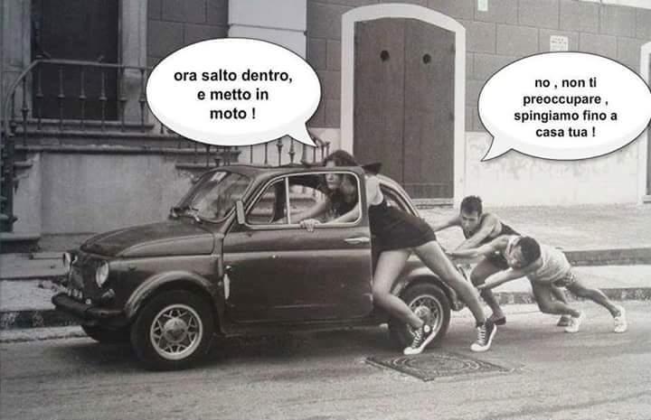 Foto Divertente: Donna che spinge auto con due ragazzi dietro