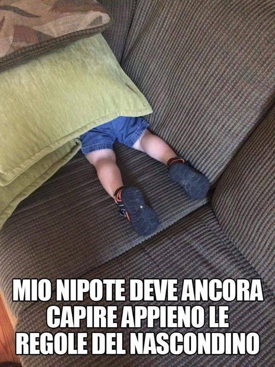 Bambino nascosto sul divano con solo i piedi fuori