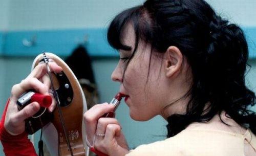 Foto Divertente: Ragazza che si trucca guardandosi nella lama del pattino
