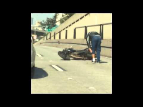 Motociclista prova a dare un calcio ad un'auto ma cade!